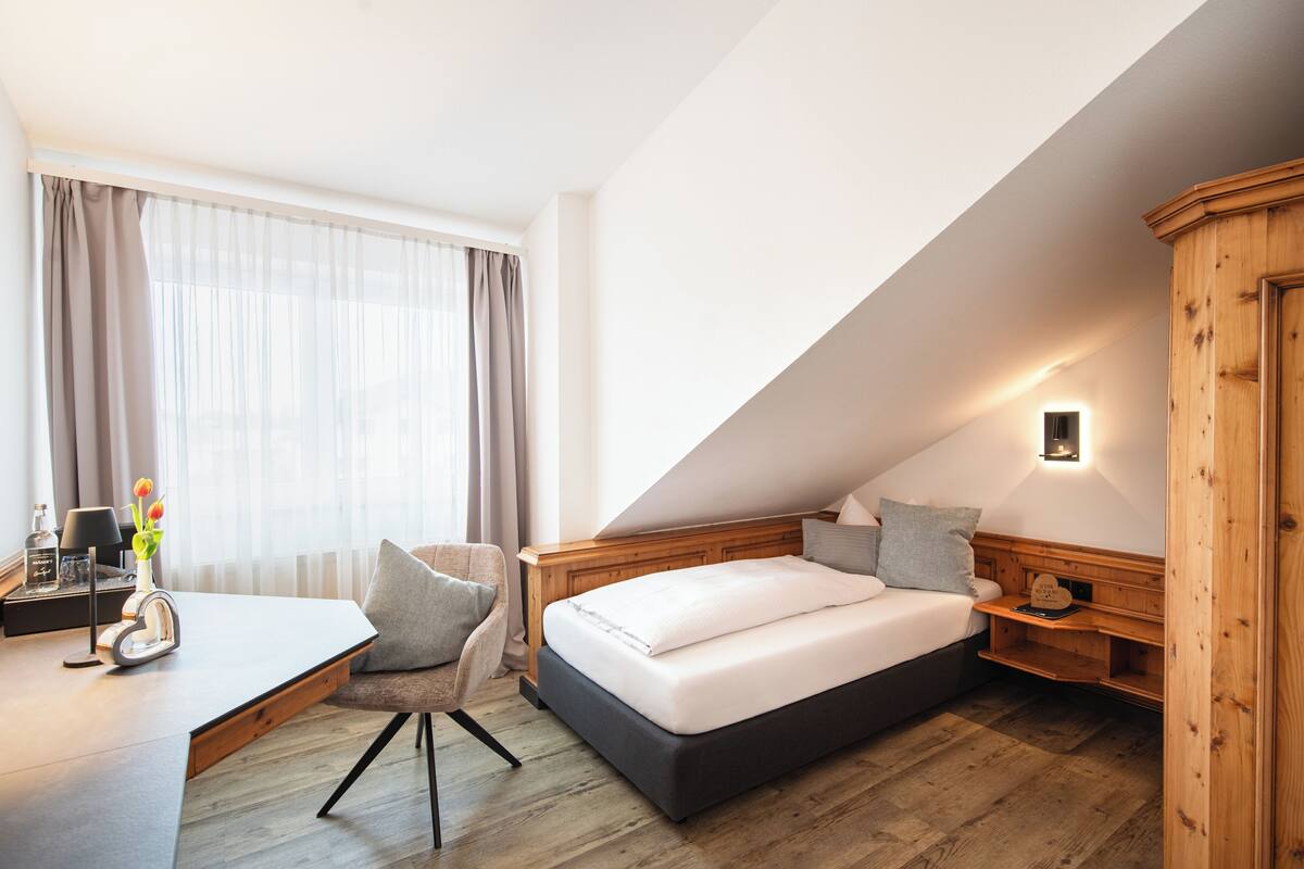 A modern bedroom with a bed, a desk, and a chair.