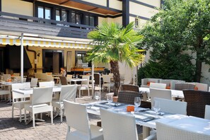 Dine al fresco amidst lush greenery and comfortable seating.