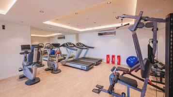 Un gimnasio con cintas de correr, elípticas y equipos de levantamiento de pesas.
