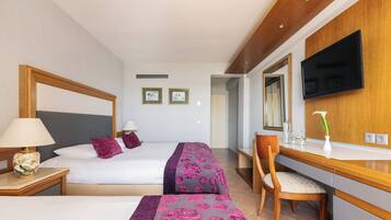 A hotel room with two beds, a desk, a chair, a TV, and a mirror.