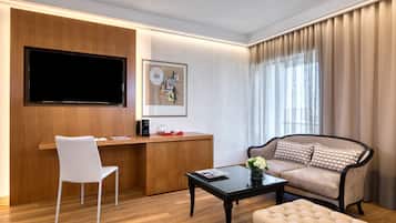Un salon moderne avec un bureau en bois, un téléviseur à écran plat, un canapé et une table basse.