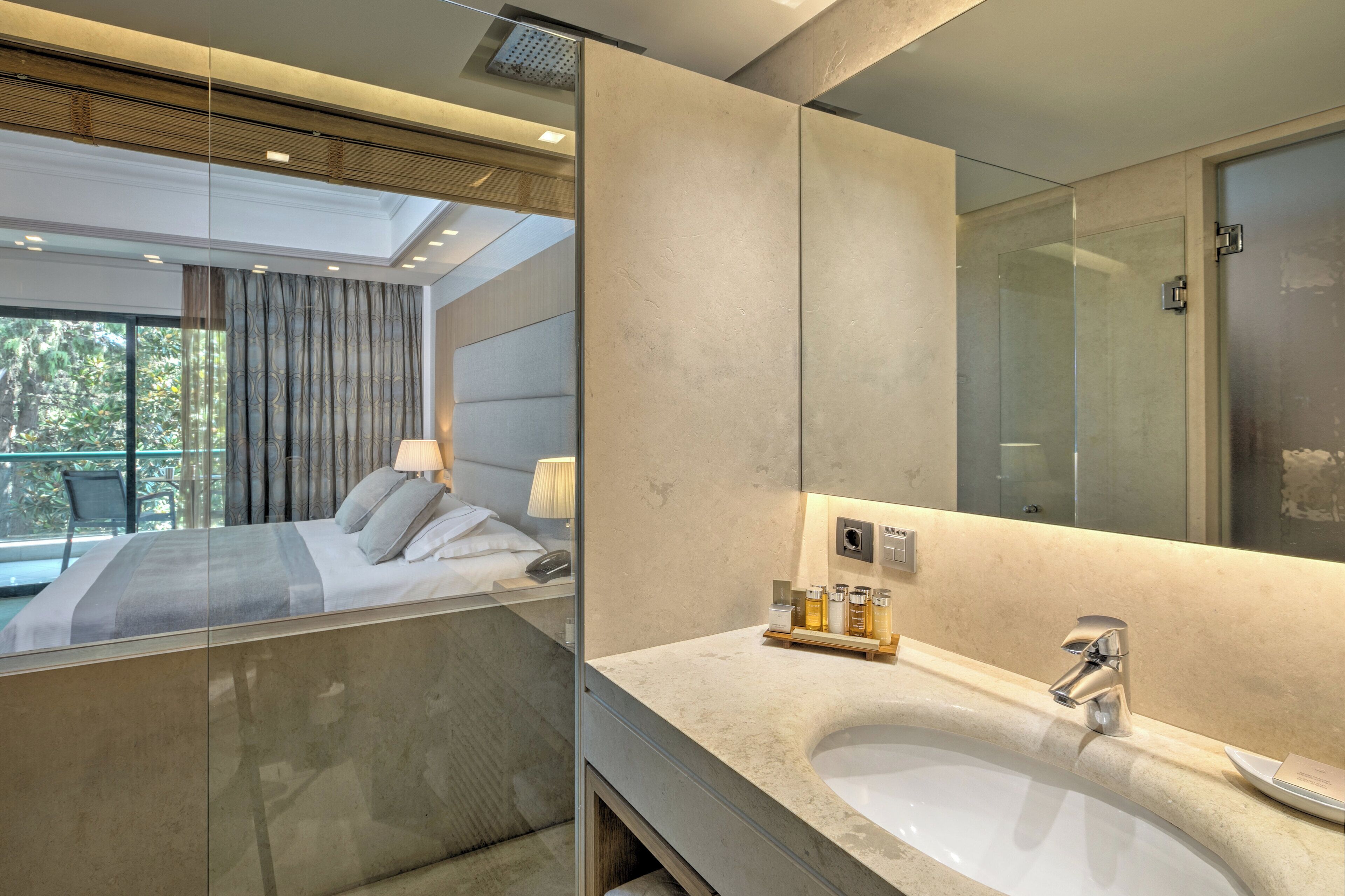A modern hotel bathroom with a large mirror, a bathtub, and a sink.