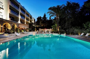 Una piscina al aire libre de temporada, sombrillas