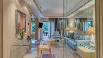 Una sala de estar moderna con un separador de vidrio, un sofá, un sillón y una mesa de centro.