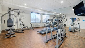 A gym with various exercise equipment, large windows, and a mounted TV. - Comfort Inn & Suites Wichita Northeast (Wichita)