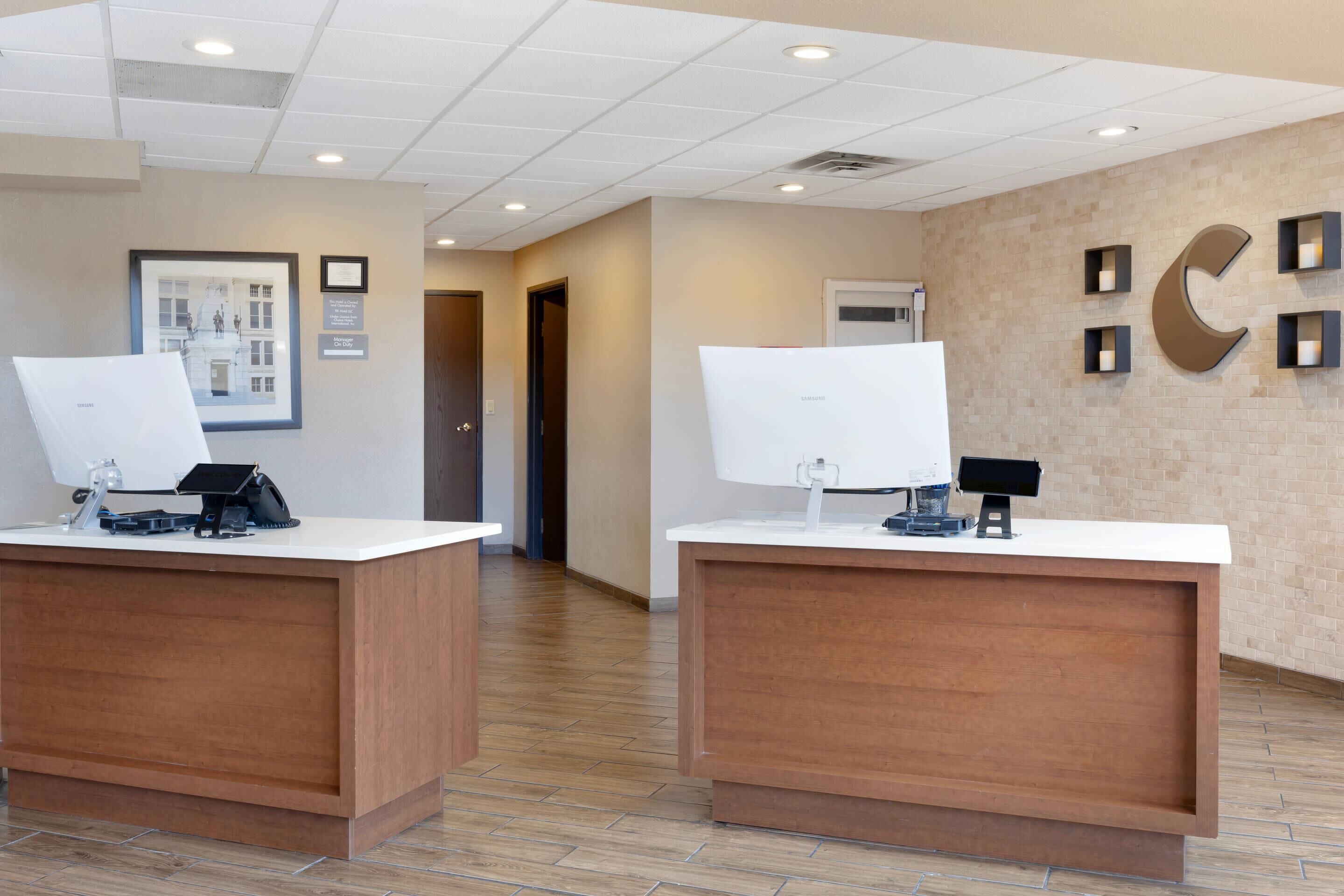 A reception desk with a computer, a telephone, and a framed picture on the wall.