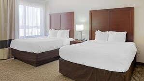 A hotel room with two beds, a nightstand with a lamp, and a window with curtains. - Comfort Inn & Suites Wichita Northeast (Wichita)