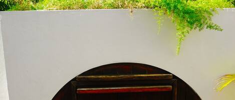 A dark wooden door with a small window and a handle, set against a white wall with a tiled base.