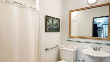Baño con inodoro, lavamanos y cortina de ducha.