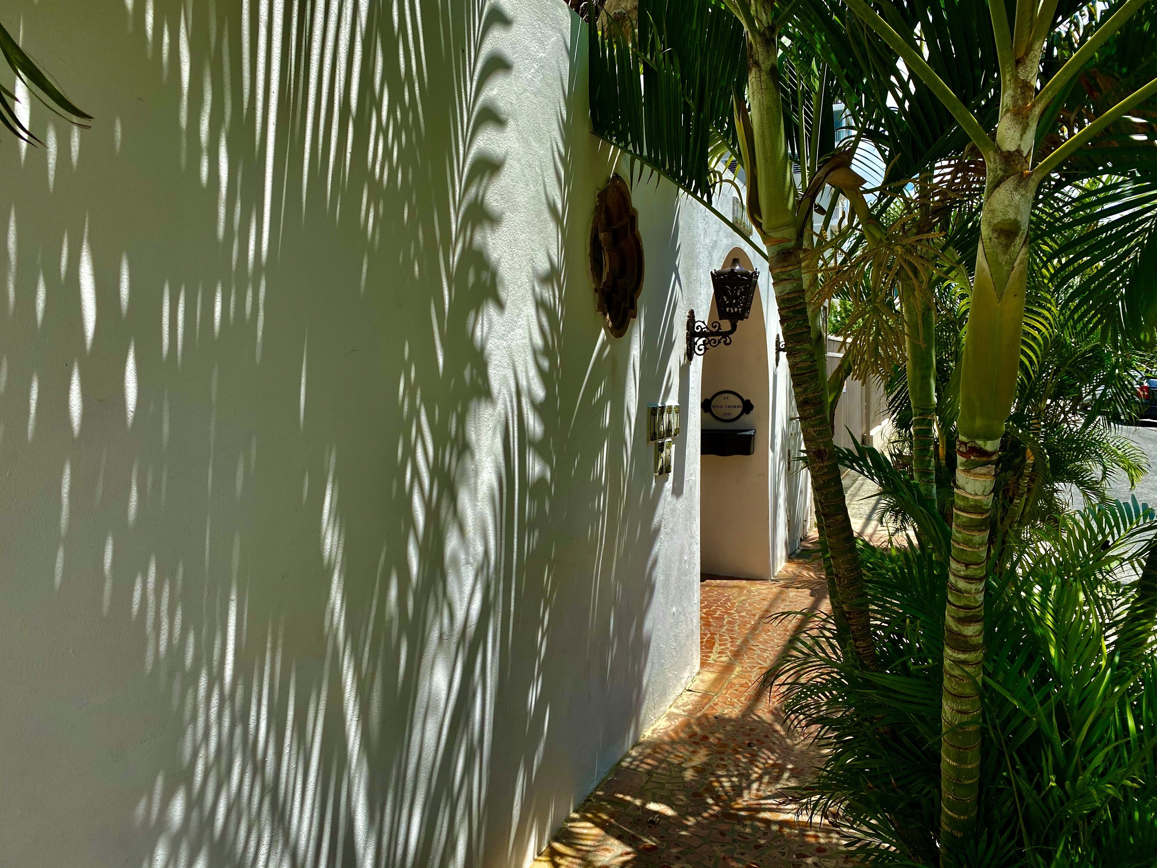 A narrow pathway leading to a building with a sign indicating a hotel.