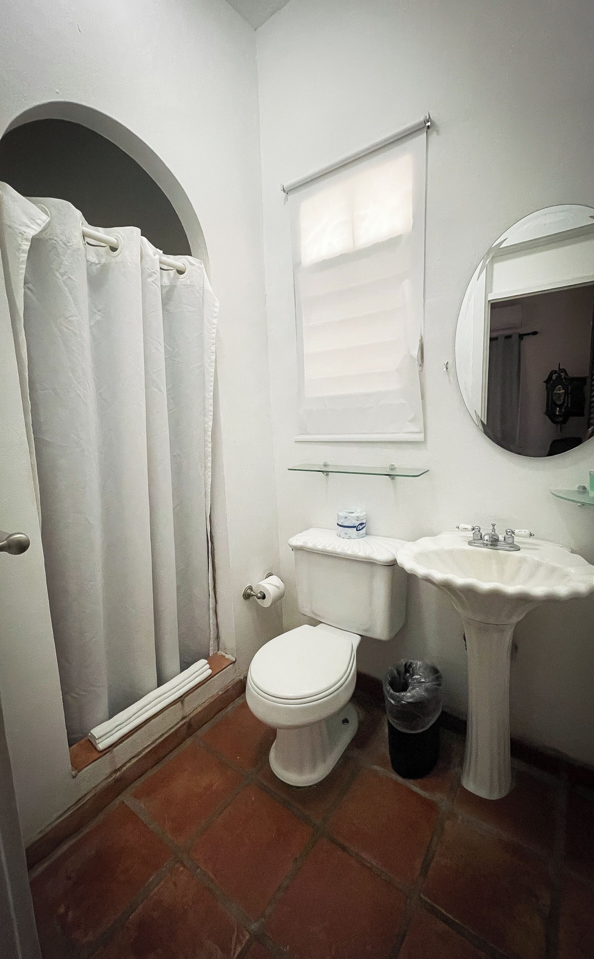 Un baño con inodoro, lavabo y cortina de ducha.