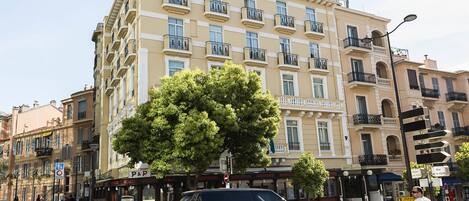 Un edificio de varios pisos con un letrero de P&P, que indica un hotel u otro establecimiento similar.