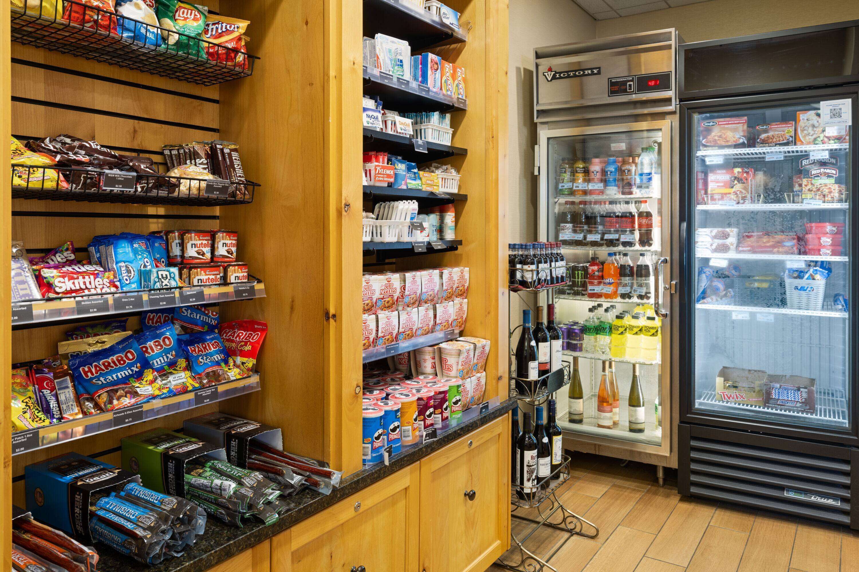 A grocery store with shelves stocked with snacks, beverages, and household items.