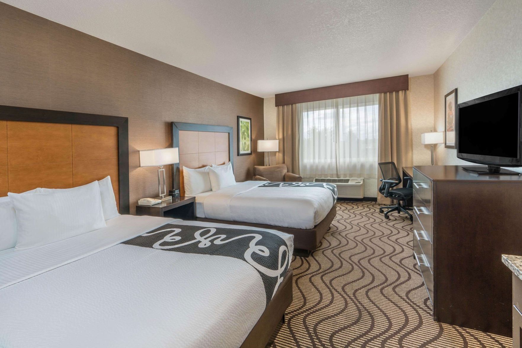 Premium bedding, desk, laptop workspace, blackout drapes