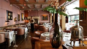 A restaurant with wooden beams, tables set with white tablecloths, and a large vase with orchids. - CAZAUDEHORE Hôtel Restaurant Gastronomique Terrasse et Jardins (Saint-Germain-en-Laye)