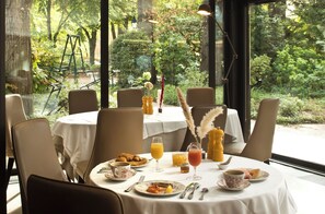 A table set for breakfast with a view of a garden. - CAZAUDEHORE Hôtel Restaurant Gastronomique Terrasse et Jardins (Saint-Germain-en-Laye)