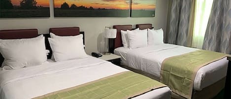 A hotel room with two beds, a nightstand, and a window with curtains.