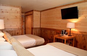A wooden-paneled room with two beds, a TV mounted on the wall, and a table with a lamp. - Reid Ridge Lodge (Blue Ridge)