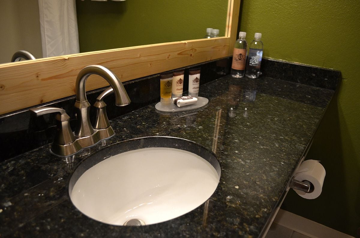 A bathroom sink with a mirror, a faucet, and toiletries on the counter.