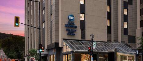 Un hotel con fachada moderna, un llamativo letrero de Best Western y entrada de vidrio.