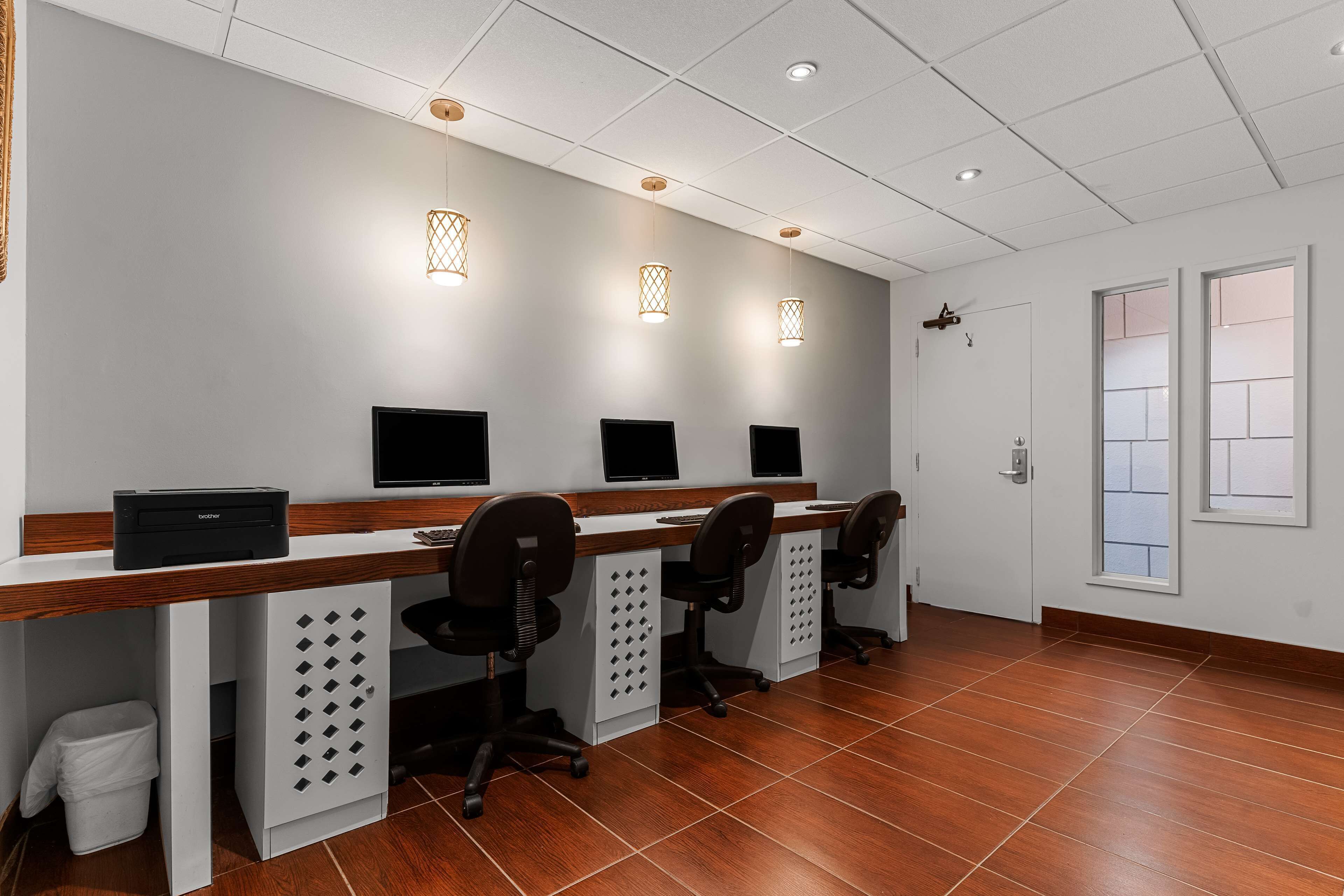 Une salle d’attente équipée de trois postes informatiques, d’une poubelle et d’une porte.