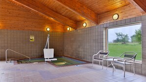 A wooden ceiling, a pool, and a window with a view of greenery. - AmericInn by Wyndham St. Cloud MN I-94 (St Cloud)