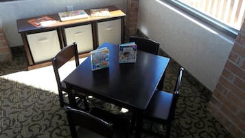Cozy room with a table and chairs, featuring a window with a view of the surrounding area.
