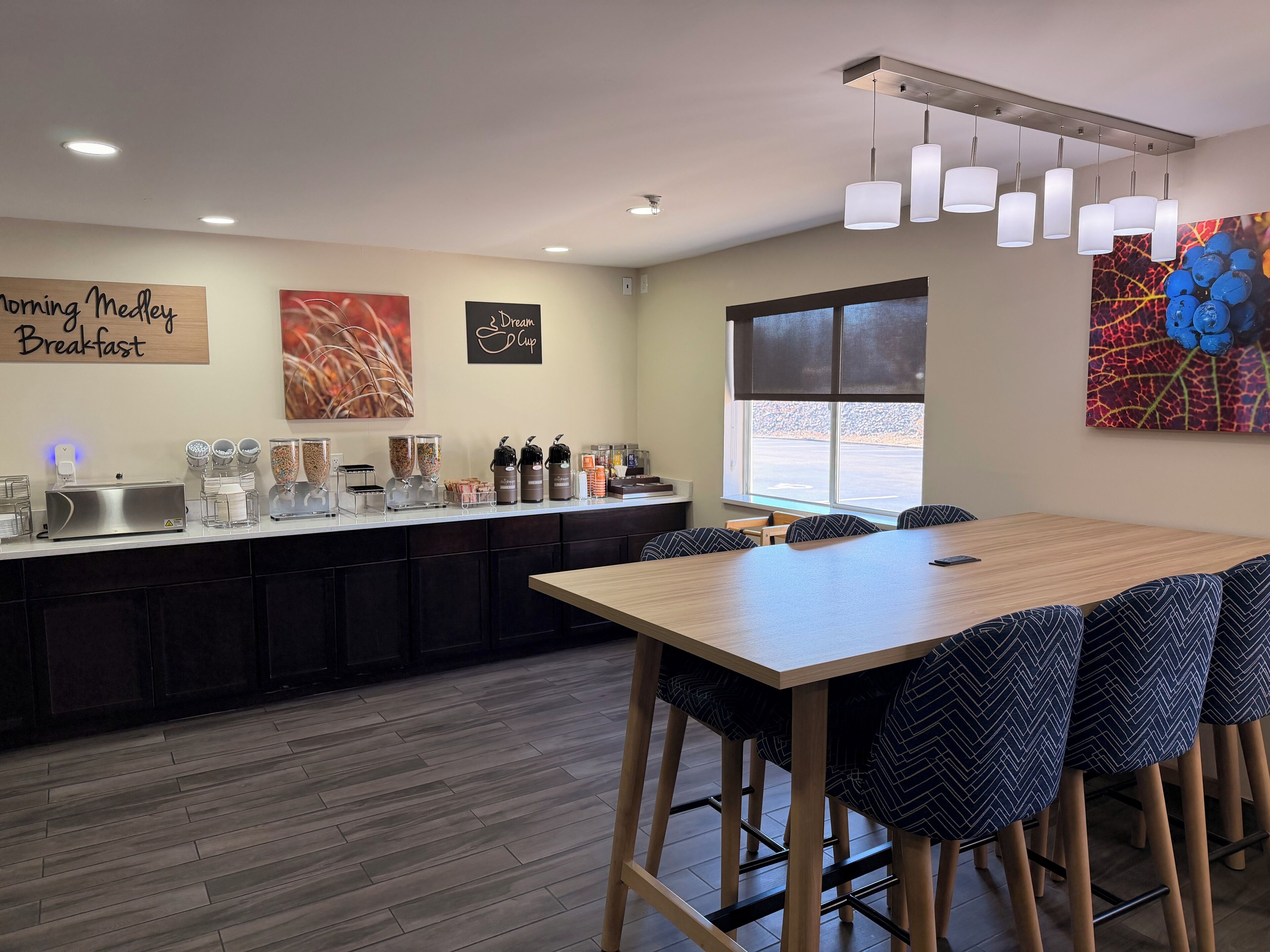 A breakfast area with a counter, seating, and artwork.