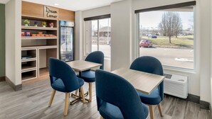 A modern interior with a 'Dream Corner' sign, a vending machine, and a view of a parking lot through large windows.