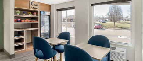 A modern interior with a 'Dream Corner' sign, a vending machine, and a view of a parking lot through large windows.