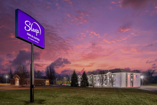 Une enseigne « Sleep Inn & Suites », un bâtiment doté d’un toit plat et un parking.