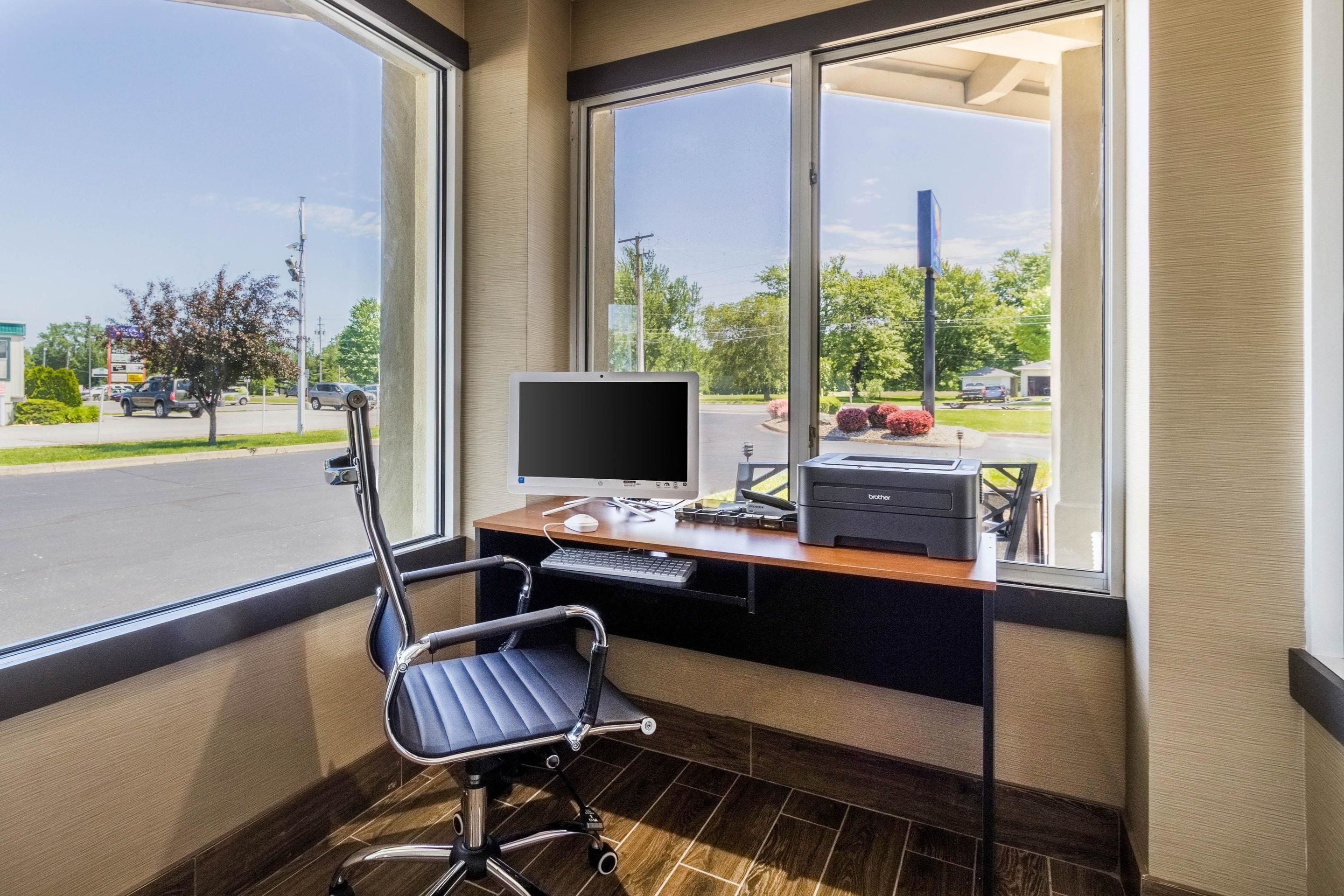 A modern office space with a desk, computer, printer, and ergonomic chair.
