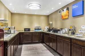 A modern kitchen with granite countertops, stainless steel appliances, and a breakfast bar. - Comfort Inn Norwalk - Sandusky (Norwalk)