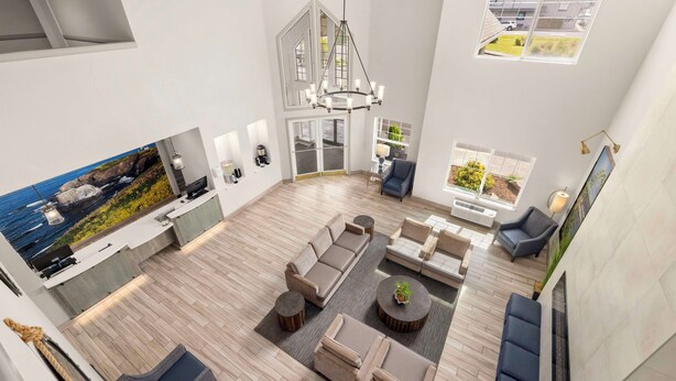 Amplia sala de estar con un amplio sofá, una mesa de comedor y una zona de cocina con vistas al exterior.