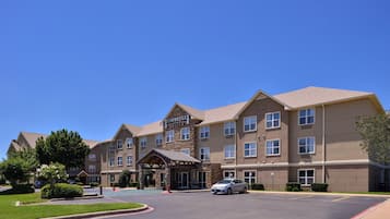 A Staybridge Suites hotel with a stone facade, multiple windows, and a covered entrance.