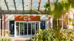 A modern building entrance with a glass door and a sign reading "Co 56 Chennitz".