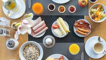 A breakfast spread with various foods and drinks on a table.