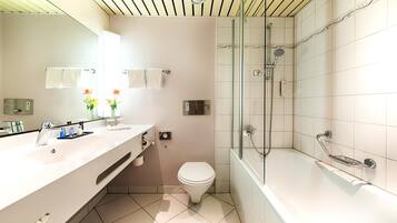 Un baño moderno con un lavamanos grande, inodoro y ducha con mampara de vidrio.