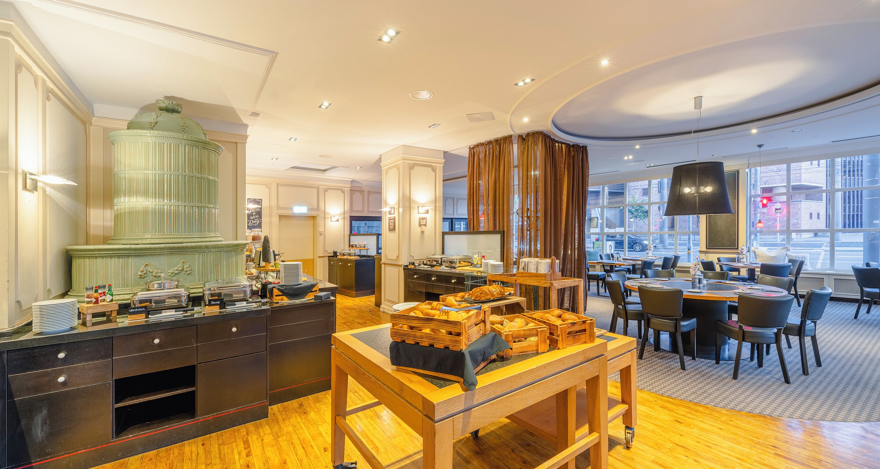 A hotel dining area with a buffet, wooden tables, and chairs.