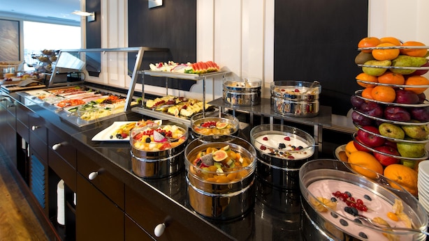 A buffet with various fruits, vegetables, and desserts.