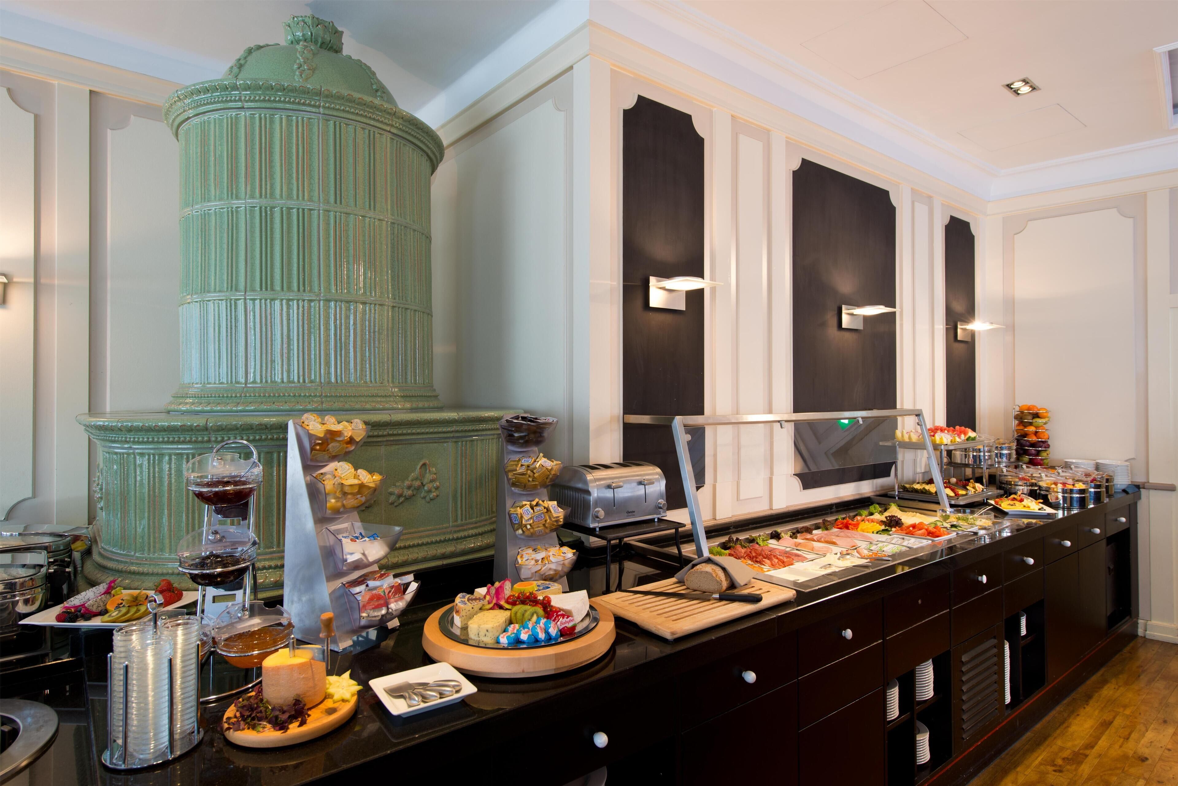 A buffet setup with various food items and a large green decorative piece.