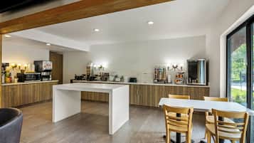 Une cuisine moderne dotée d’un îlot central, de meubles en bois et d’un coin repas avec une table et des chaises.