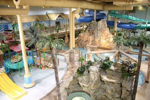 Parque acuático interior con toboganes, zona de escalada en roca y piscina.