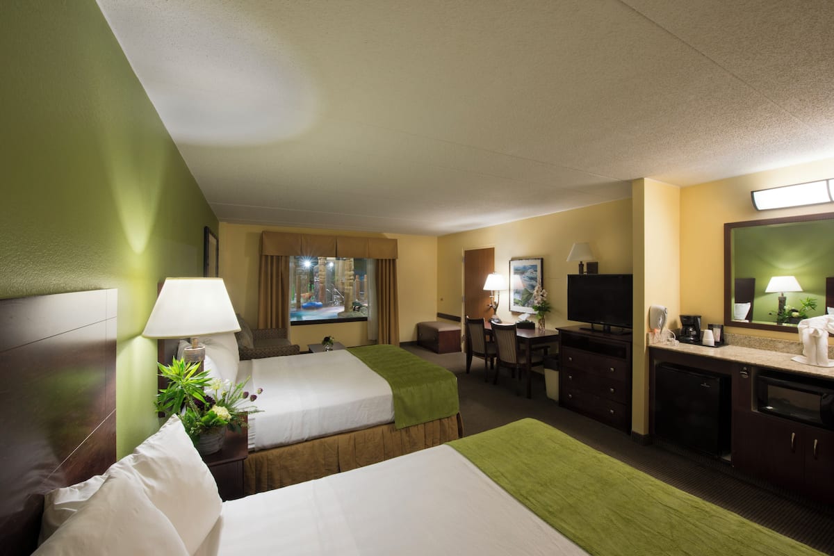 Une chambre d’hôtel avec deux lits, un bureau, une télévision et une salle de bain.