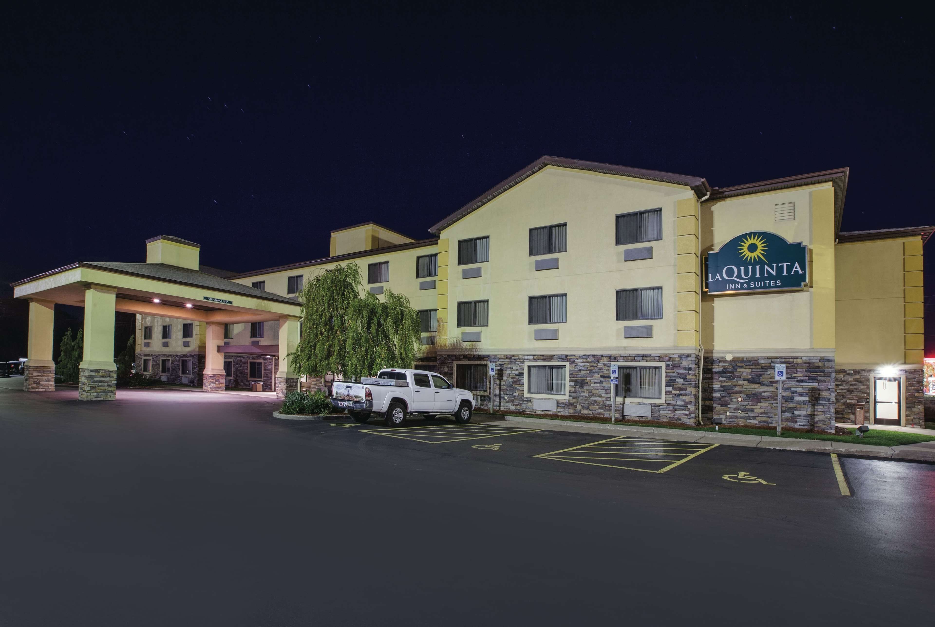 A hotel with a sign reading "La Quinta Inn & Suites" at night.