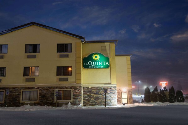 A hotel named La Quinta Inn & Suites with a stone facade and a signboard.
