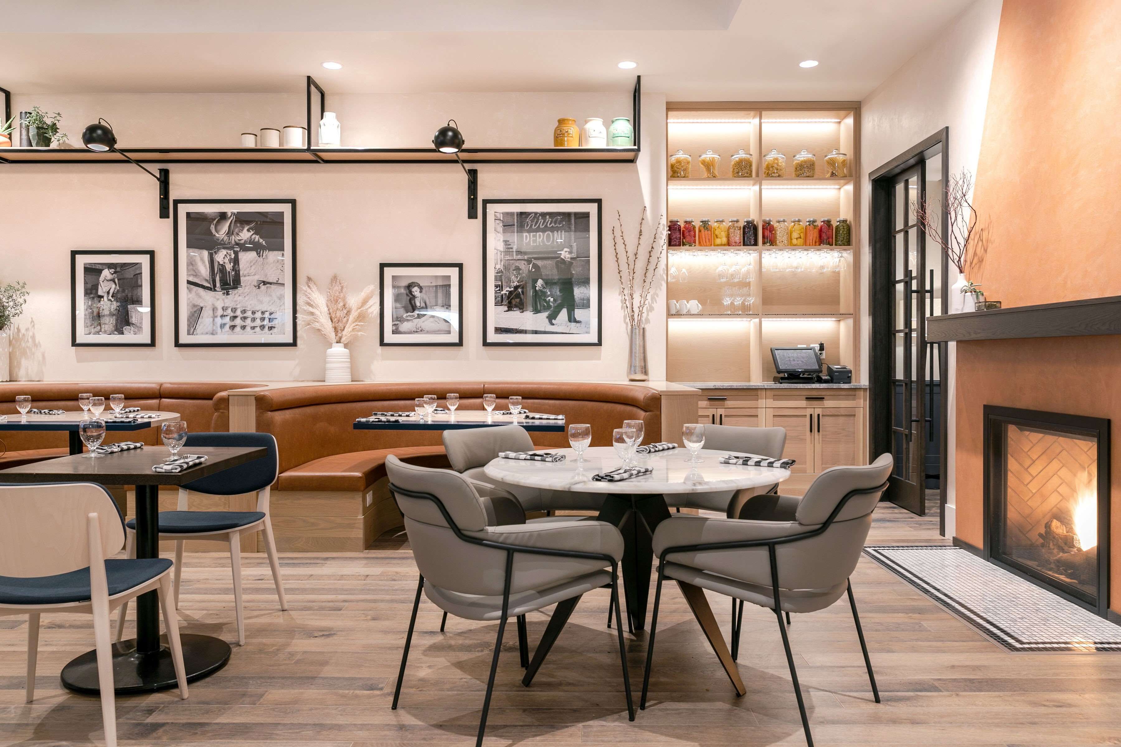 Un espace repas moderne comprenant une table ronde, des chaises, un canapé et une cheminée.