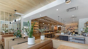 A modern restaurant with wooden booths, a central counter, and pendant lighting. - Best Western Plus Baker Street Inn (Nelson)