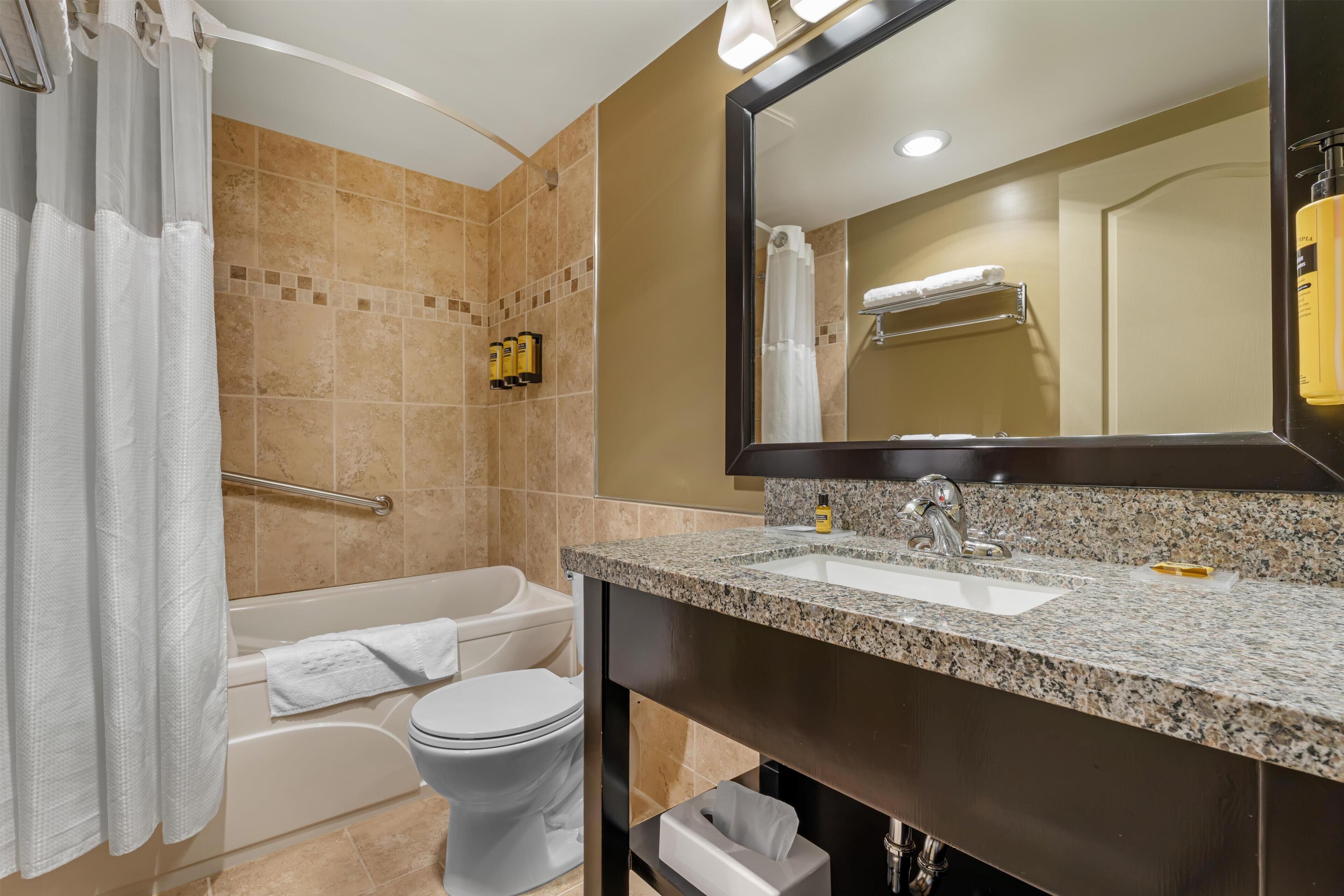 A modern bathroom with a bathtub, toilet, and sink.