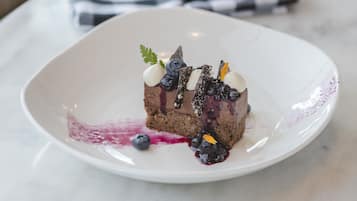 Un postre sobre un plato blanco, con un mantel a cuadros al fondo.
